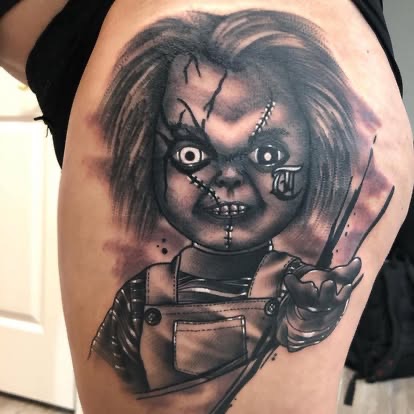 Black and grey realism Chucky horror doll tattoo on the thigh