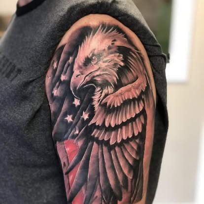 Black and grey realism eagle with American flag tattoo on the shoulder
