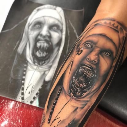 Black and grey realism tattoo of The Nun (Valak) horror portrait on the forearm