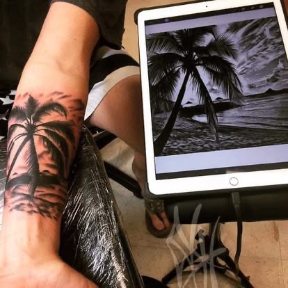 Black and grey realism palm tree beach scene tattoo on the forearm