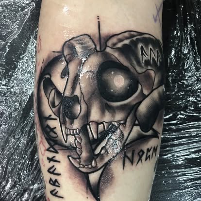 Blackwork sketch-style animal skull with runes tattoo on the forearm