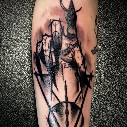 Dark blackwork abstract dagger and hand with barbed wire tattoo on the forearm