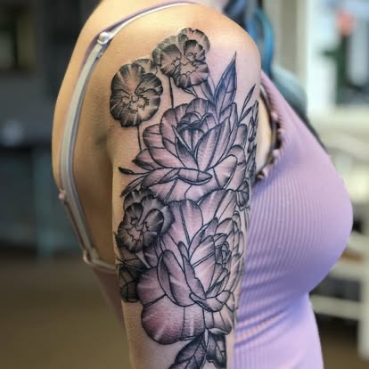 Blackwork fine-line peony floral half-sleeve tattoo on the upper arm