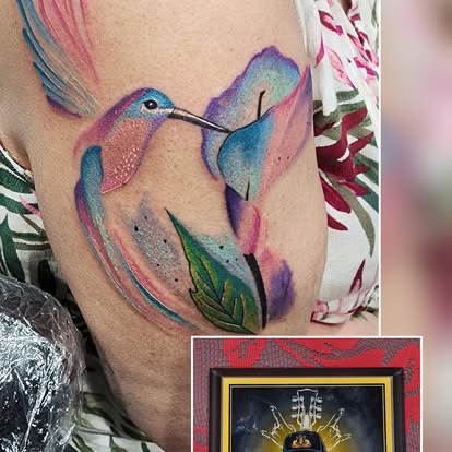 Watercolor pink and blue hummingbird tattoo on the arm