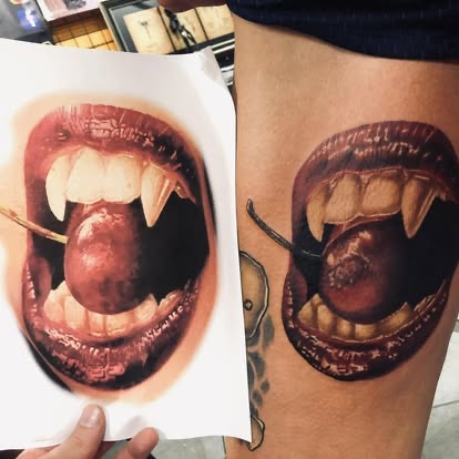 Color realism vampire mouth with fangs and a cherry tattoo on the thigh