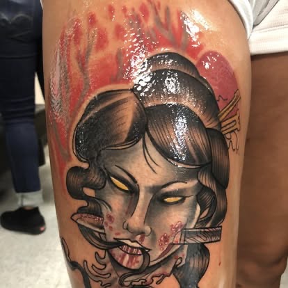 Neo-traditional color tattoo of a severed geisha head with a knife and red background on the thigh