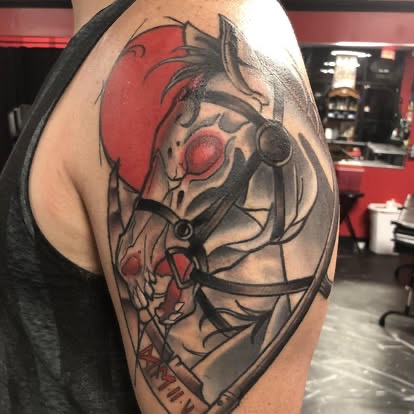 Neo-traditional black and grey armored horse skull with red moon tattoo on the shoulder