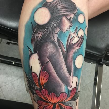 Neo-traditional color tattoo of a woman with glowing moon orbs and a lotus on a blue background