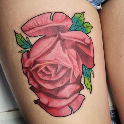 Neo-traditional pink rose tattoo with green leaves on the thigh